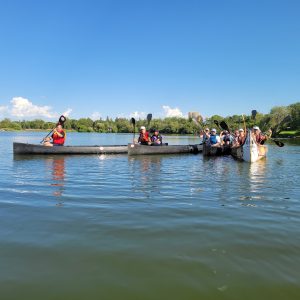 A group of people in canoes on a lake.