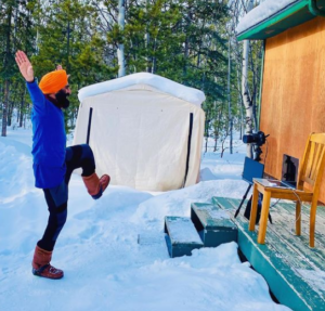 Gurdeep Pandher dancing on snow in front of a cottage.