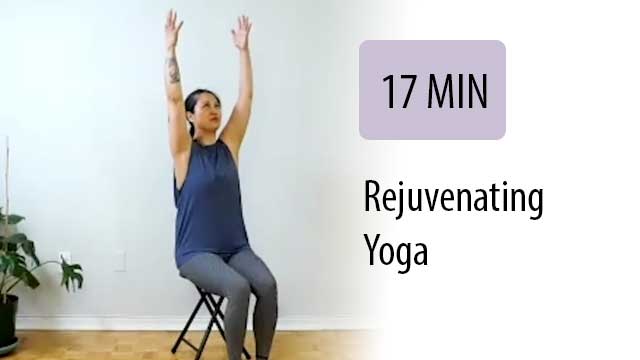 woman in chair foin yoga reaching up above her head with both hands