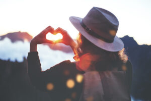 A woman making a heart shape with her hands.