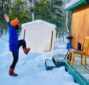 Gurdeep Pandher danse dans la neige devant un chalet.