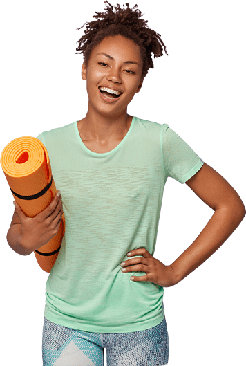A woman smiling and holding an orange yoga mat A woman smiling and holding an orange yoga mat