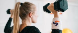 woman lifting weights with pac wristband on