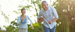An older couple playing football. Staying active as you age has many benefits.
