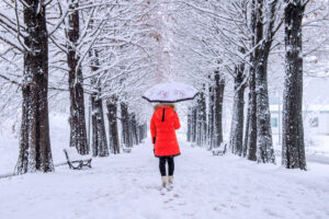 Une femme marche sur un sentier enneigé pour éviter l'épuisement de fin d'année.