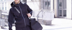 A man walking while carrying a duffle bag. He is about to play sports, one of many great after work activity ideas.