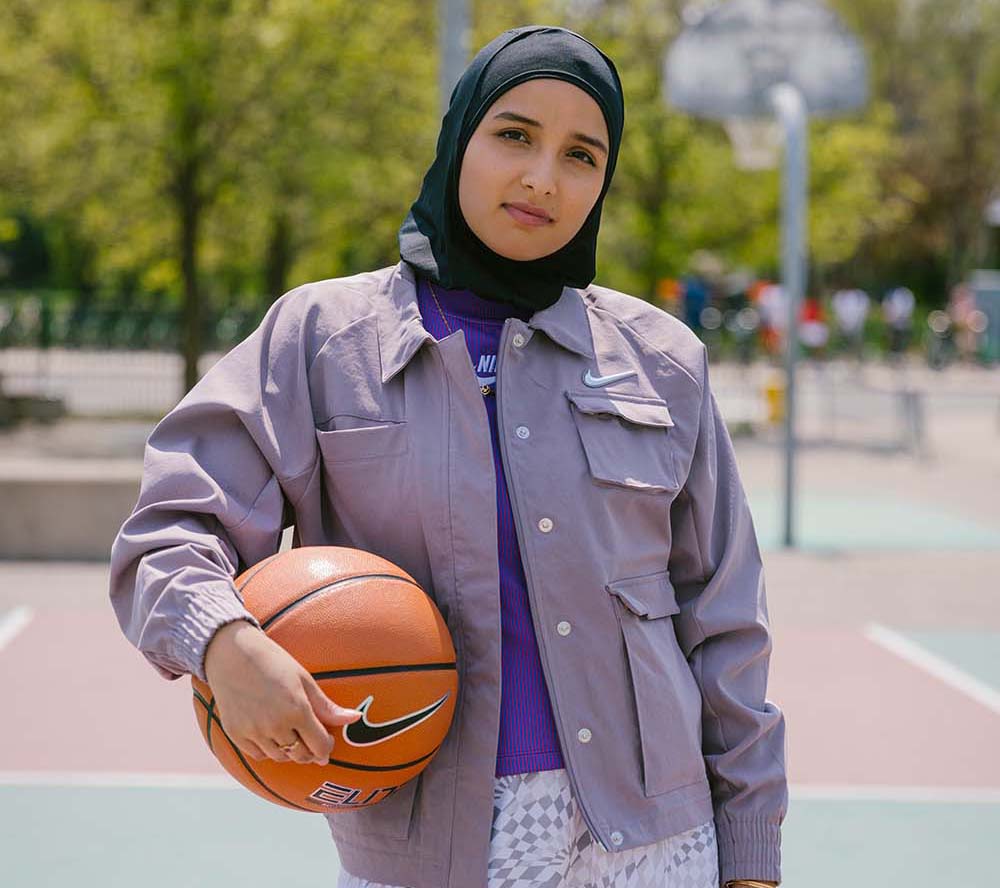 Amreen Kadwa holding a basketball while standing on a basketball court. 