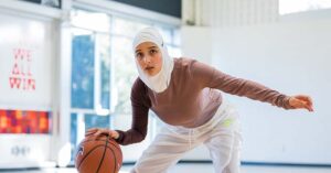 Muslim athlete Amreen Kadwa dribbling a basketball. .
