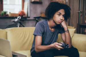 Un adolescent qui s'ennuie devant la télévision.