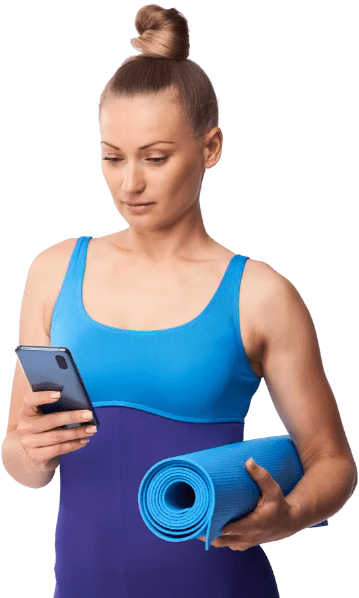 Une femme en tenue d’entraînement qui tient un tapis de yoga bleu et consulte son téléphone est entourée de bulles de notifications de l’application