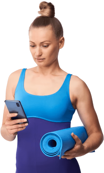 A woman in activewear and holding a blue yoga mat checks her phone and is surrounded by pop up app notifications A woman in activewear and holding a blue yoga mat checks her phone and is surrounded by pop up app notifications
