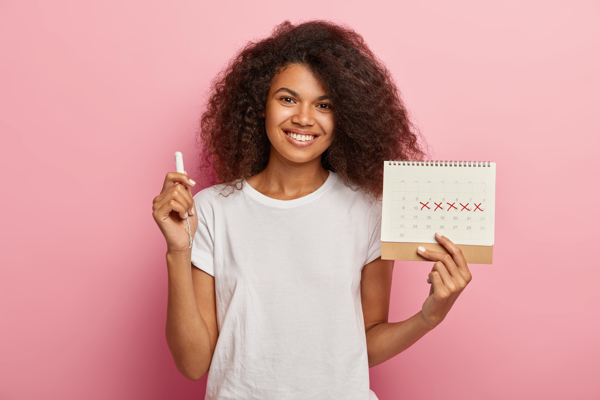 A woman holding a calendar and a tampon