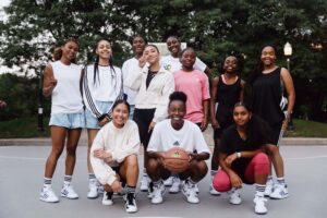 Olivia Ho se tient avec un groupe de joueuses actives de basket-ball.