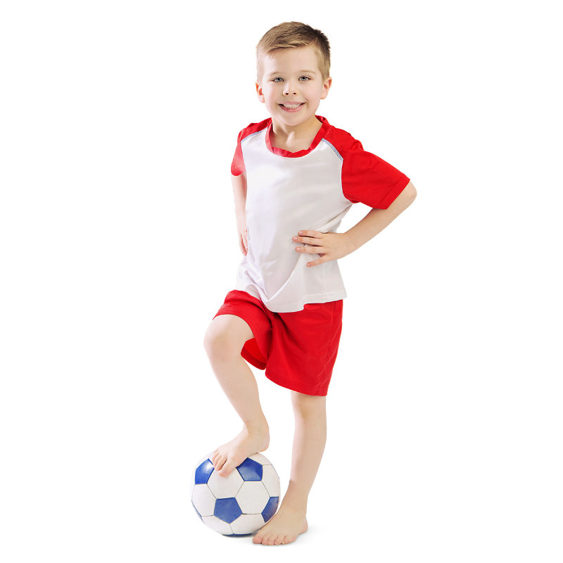 Happy little boy, posing and holding a soccer ball with his foot
