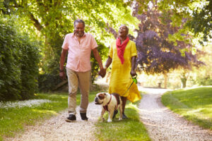 Un couple promenant leur chien sur un sentier naturel.