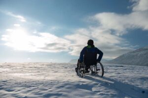 man in a chair wheeling on snow