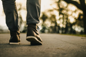 A person walking on a sidewalk. They take active breaks.