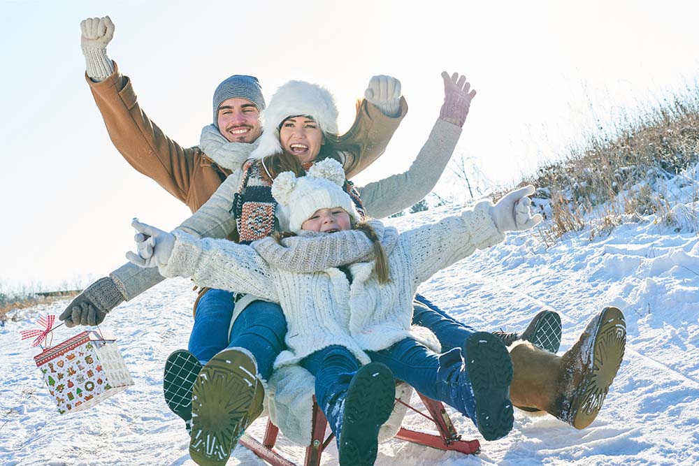 A family tobogganing in December.  