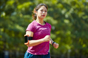 Une femme faisant son jogging avec un téléphone attaché à son bras.