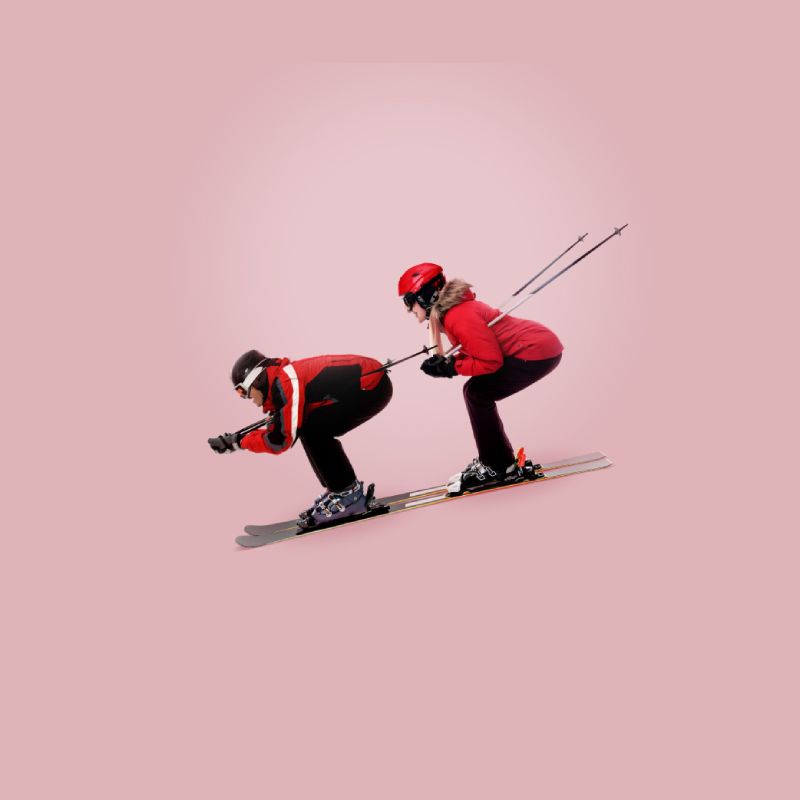 A man and woman downhill skiing together