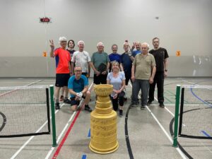 Group of seniors posing in front of a championship cup