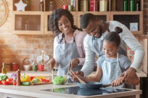 A smiling family cooking together to fuel their movement. 