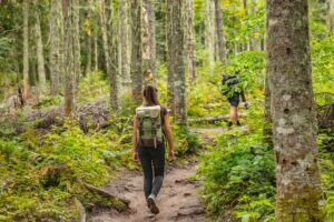 Two people walking on a nature trail.