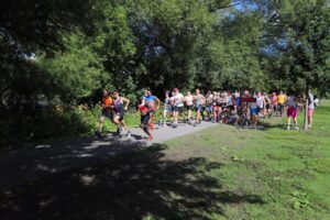 Les participants et participantes de la course de la Fierté dans la Capitale Nationale 2022 courent sur un sentier de parc. 2ELGBTQQIA+