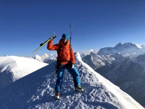 Jill Wheatley avec des skis et des bâtons sur le sommet Mera (6 476 mètres) au Népal, avec le mont Everest en arrière-plan; elle brave l' adversité. 