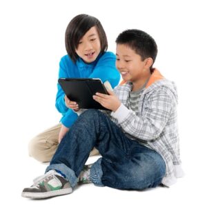 Two boys looking at a tablet screen.