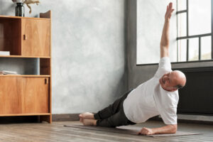 A man doing yoga in a living room. 