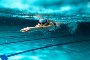 A woman swimming underwater in a pool. 