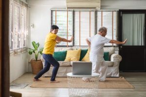A man and woman doing tai chi in a living room.