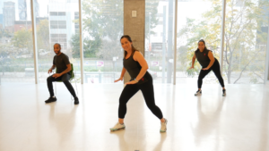 Three people dancing in a workout studio.