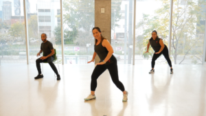 Three people dancing in a workout studio. 