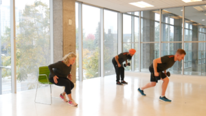 Three people bent over while holding pairs of dumbbells. 