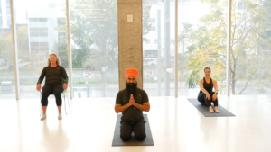 Three people doing yoga poses in a yoga studio.