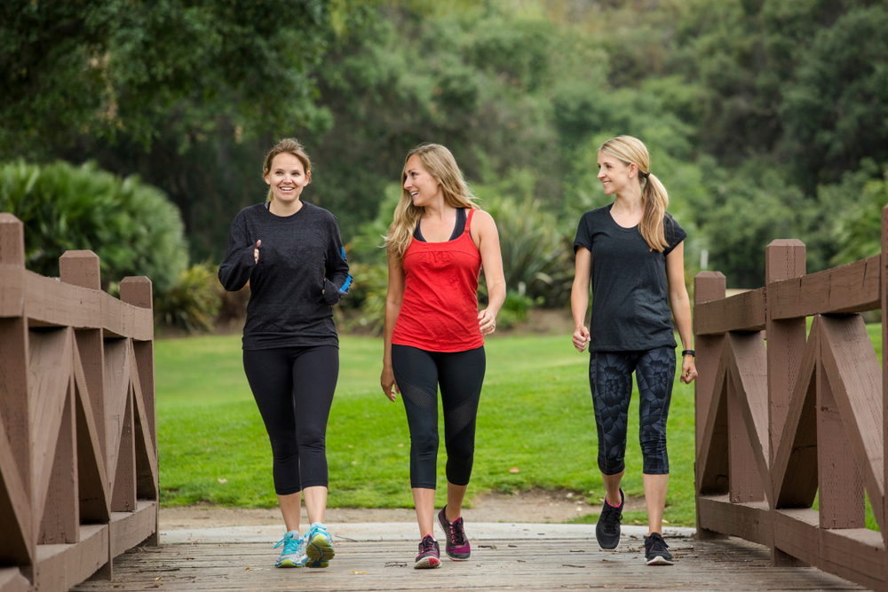 A group of women walking together on a park path.