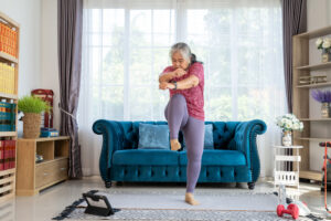 A woman doing the high knees exercise in her living room. 