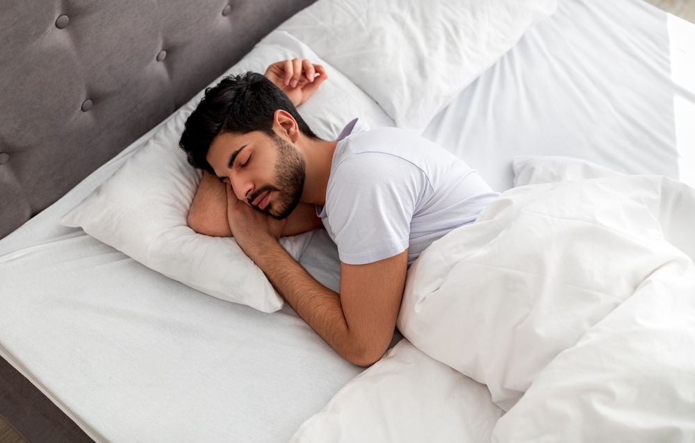 A man sleeping in a bed.