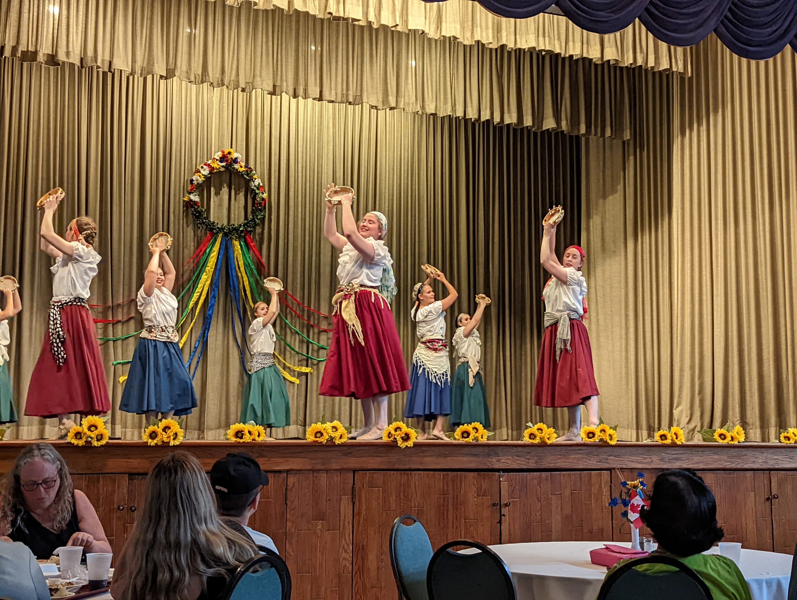 Ukrainian dancers dancing on a stage in front of an audience.