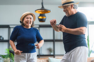 Two people dance like no ones watching in a living room. 