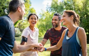 Un groupe de personnes souriantes se serrant la main dans un parc dans la communauté.