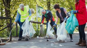 A group of people picking up trash in a park.