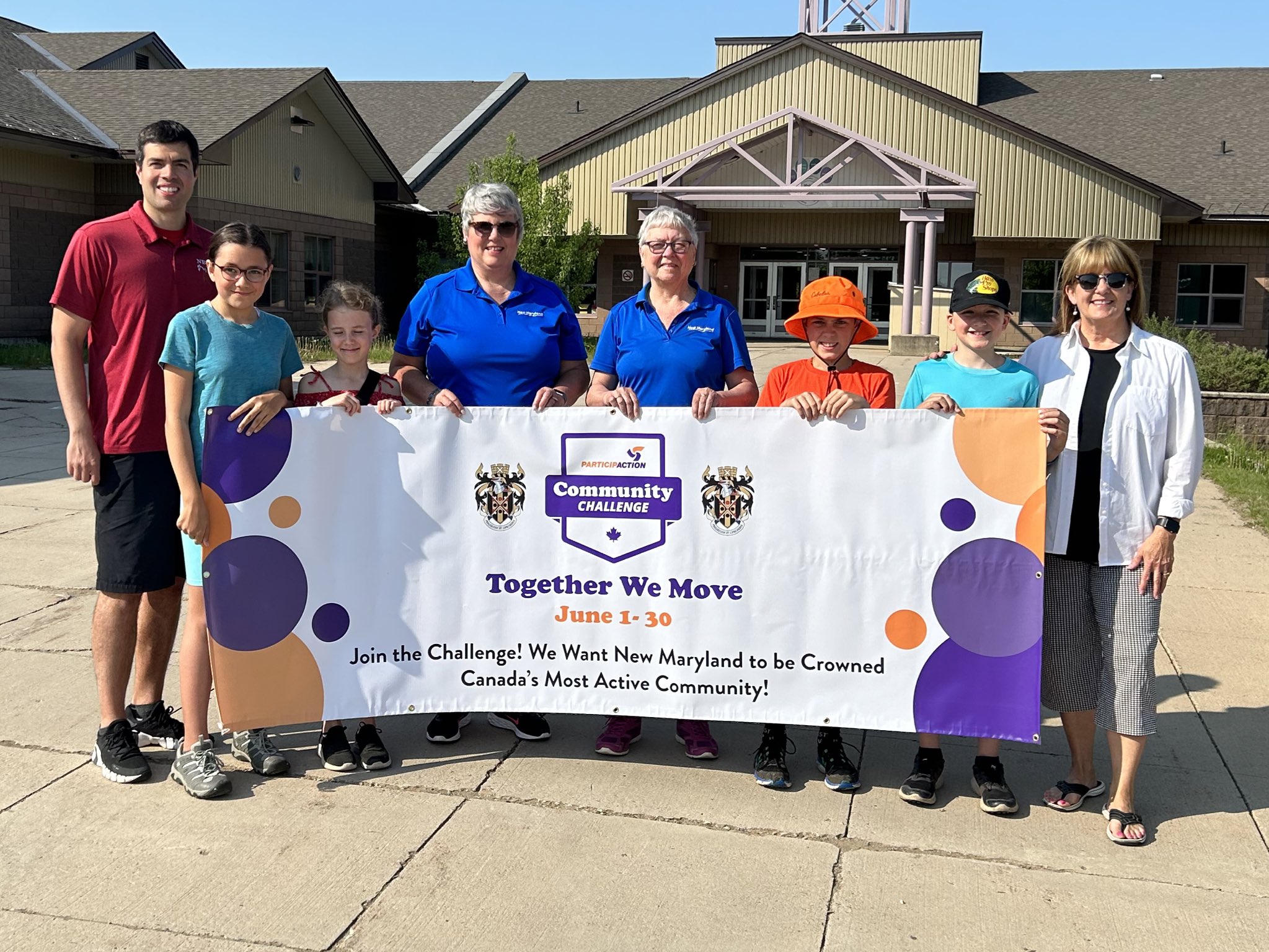 group of people holding up a community challenge banner