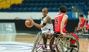 Two teenage boys playing wheelchair basketball.