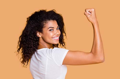 woman smiling and flexing one arm