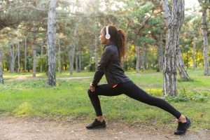 A woman doing walking lunges in a park.