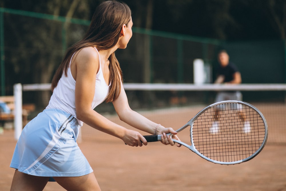 A woman playing tennis outdoors. 