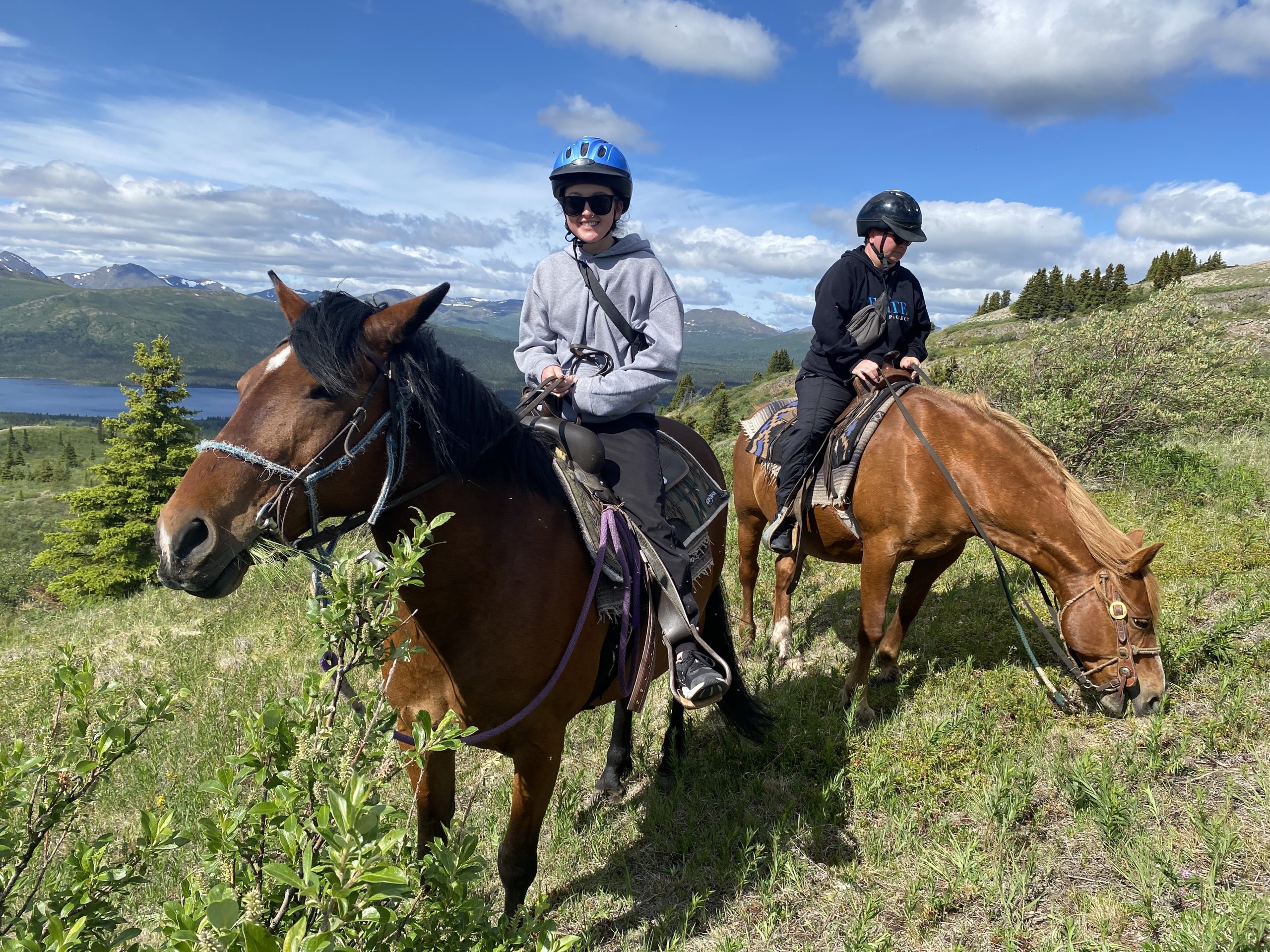 Madison and her mom riding horses on a hill.